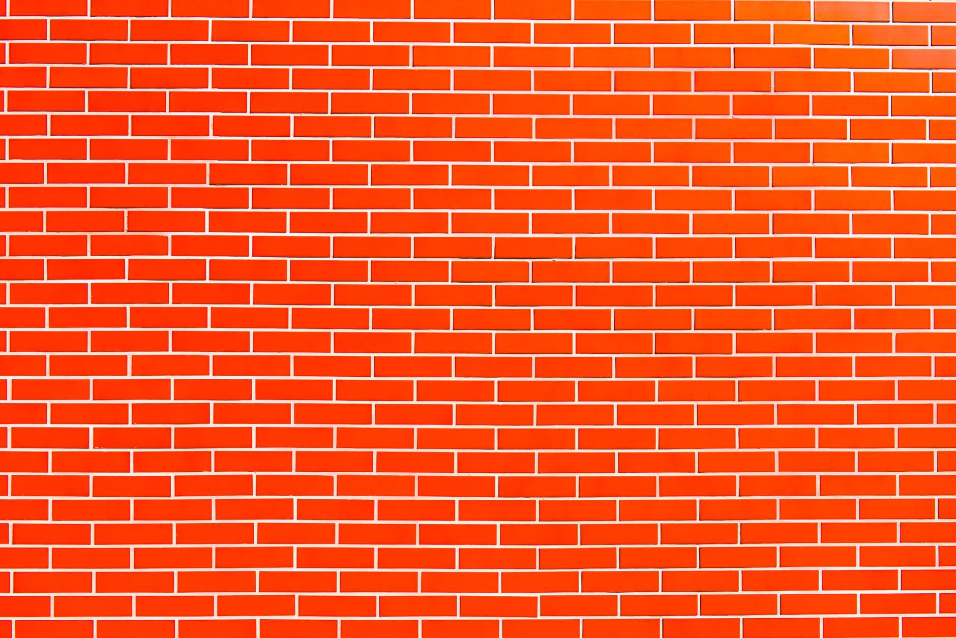 Oranje bakstenen muur met witte voegen